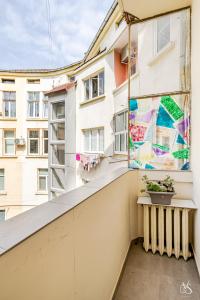 ein Balkon mit einem Fenster mit einem Gemälde in der Unterkunft Luxury And Spacious Apartment at the Hearth of the City in Sofia