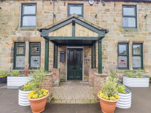 a stone building with pots of plants in front of it at Apartments at The Black in Wark