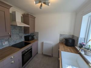 a kitchen with a sink and a stove at Tranquil 3-Bedroom Home in Edinburgh in Edinburgh