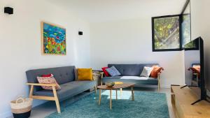 a living room with a couch and a table at 3 pièces avec piscine privative in Collioure