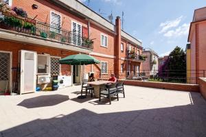 a person sitting at a table under a green umbrella at La Terrazza di Stefy in Acilia