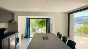 a kitchen with a large table and a large window at 3 pièces avec piscine privative in Collioure
