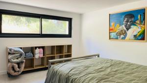 a bedroom with a bed and a large window at 3 pièces avec piscine privative in Collioure