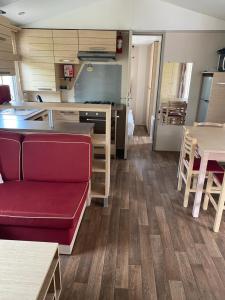a living room with a couch and a kitchen at Mobil Home dans le camping 4 étoiles le Montourey in Fréjus +4 photos