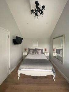 ein Schlafzimmer mit einem großen Bett und einem Kronleuchter in der Unterkunft Thimble Cottage in Buckinghamshire