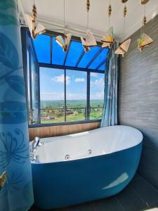 Buôn Dhă PrŏngにあるKakul A'Houseの大きな窓のある浴室の浴槽