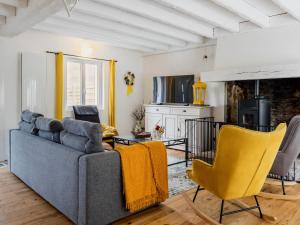 un salon avec un canapé et des chaises jaunes dans l'établissement Chaumière au calme avec terrasse, à 9 km des plages, 3 chambres, parking privé et équipements bébé. - FR-1-306-1276, à Saint-Lyphard 8 autres photos