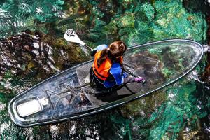 a woman is on a kayak in the water at Hotel New Akao in Atami