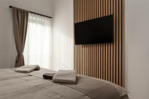 a bedroom with a bed with a television on the wall at Holiday House ARNI in Delnice