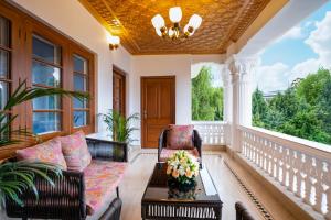 RājbāghMoghal Mahal Resort Rajbagh Srinagar的一个带沙发和桌子的门廊