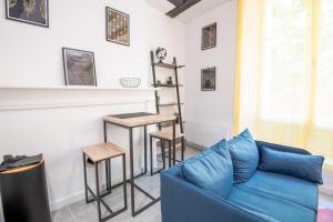 a living room with a blue couch and a table at La Cachette d'Amboise - Appart. 2 pers. in Amboise