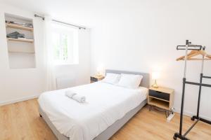 a bedroom with a white bed and a window at La Cachette d'Amboise - Appart. 2 pers. in Amboise