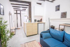 a living room with a blue couch and a kitchen at La Cachette d'Amboise - Appart. 2 pers. in Amboise