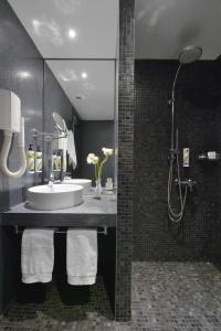 a bathroom with a sink and a shower at Airotel Patras Smart Hotel in Patra