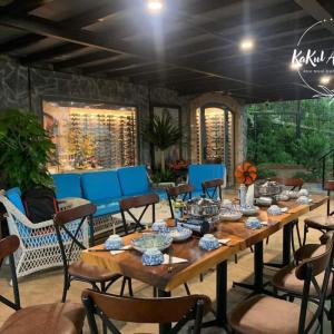 Buôn Dhă PrŏngにあるKakul A'Houseのパティオにある長い木製のテーブルと青い椅子