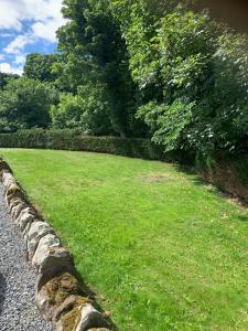a grassy field next to a stone wall at The Cottage at Hillhead Farm in St. Andrews
