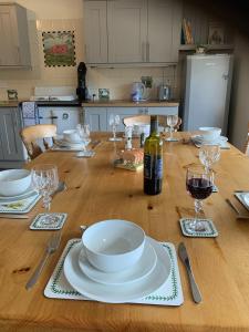 a wooden table with a bottle of wine and glasses at The Cottage at Hillhead Farm in St. Andrews