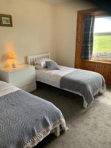 two beds in a bedroom with a window at The Cottage at Hillhead Farm in St. Andrews