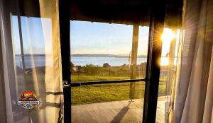 an open door with a view of the water at Cabana Doris Coronini in Moldova Veche