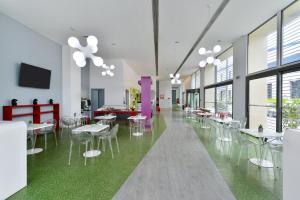 a cafeteria with white tables and chairs and windows at Airotel Patras Smart Hotel in Patra