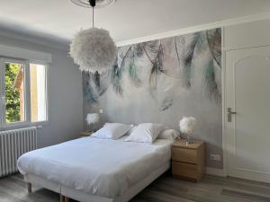 a bedroom with a bed and a painting of feathers at Gite la Plume in Amboise
