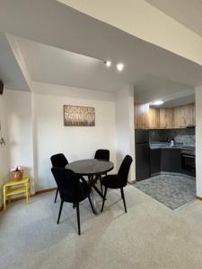 Una sala de estar con mesa y sillas y una cocina. en Urban Loft, en Skopje