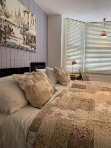 a bedroom with two beds with pillows and a window at Relax Inn Guest House in Brighton & Hove