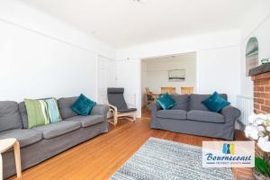 a living room with a gray couch and blue pillows at Bournecoast Family chalet bungalow - garden -9600 in Mudeford