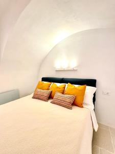 a bedroom with a bed with orange and white pillows at Evo Suite & Spa in Vieste +17 photos