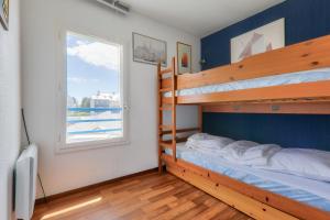 Un dormitorio con dos literas y una ventana. en Vue sur le port du Crouesty, appartement pour 5, en Arzon