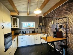 a kitchen with white cabinets and a table in it at GłuszaSpot Dom Odyn in Bytoń +50 photos