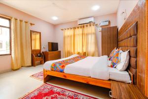 a bedroom with a large bed and a television at FabHotel Grand Comforts in Haidarpur