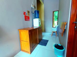 a kitchen with a wooden cabinet and a microwave at Wisma Kencana Syariah near UNS Mitra RedDoorz in Kemiri