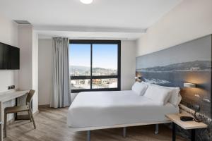 ビーゴにあるB&B HOTEL Vigoの大きなベッドと大きな窓があるホテルの部屋