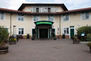 un gran edificio blanco con un patio de ladrillo en The Little Haven Hotel, en South Shields