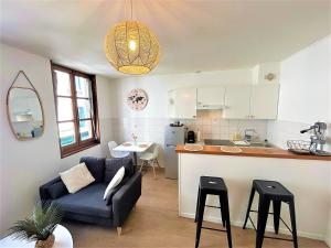 a living room and kitchen with a couch and a table at Appartement à 150 m de la cathédrale in Rodez