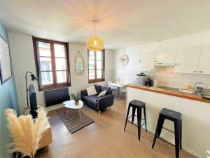 a kitchen and living room with a couch and a table at Appartement à 150 m de la cathédrale in Rodez +11 photos