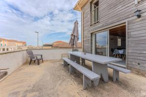 ミミザンにあるMaison Bord De L'Océan 3 étoilesの建物の隣のパティオにピクニックテーブル