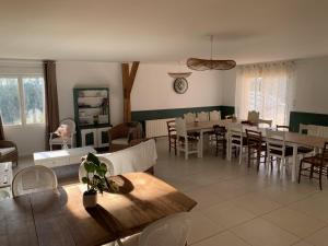 a living room with tables and chairs and a dining room at Gite de Groupe Aux Instants Partagés in Fontenay-sur-Vègre