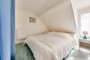 a bedroom with a white bed and a window at À 350m du bord de mer, maison pour 4 in Saint-Pierre-Quiberon