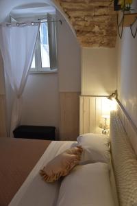 une chambre avec un lit avec un oreiller et une fenêtre dans l'établissement Piccola Pietra, à Martina Franca