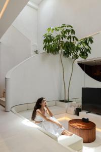 チャングーにあるVOX Villas Cangguの居間のソファに座る女性