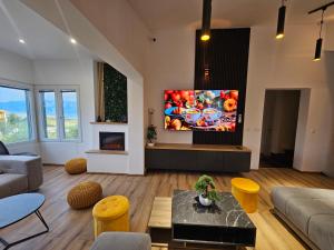 TV a/nebo společenská místnost v ubytování Villa Izziy by the beach with a sea view and heated pool