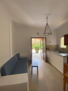 un soggiorno con un divano blu e una cucina di Hestia Greekgod Apartments a Sidari