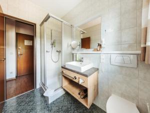un bagno con lavandino e doccia di Regitnig - 4 Sterne Hotel und Chalets a Weissensee