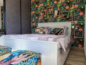 a bedroom with a tropical wall with a bed at Les Papillons d'Uzès in Saint-Laurent-la-Vernède