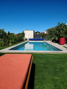 a swimming pool with a bench in the grass at Les Papillons d'Uzès in Saint-Laurent-la-Vernède