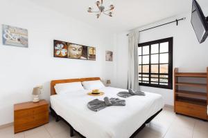 a bedroom with a large white bed with towels on it at Volcanoes and Ocean Views in Arona +21 photos