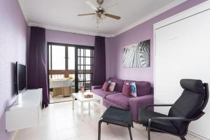 a purple living room with a purple couch and a chair at Volcanoes and Ocean Views in Arona
