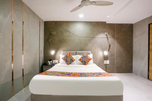 um quarto com uma grande cama branca com travesseiros laranja em FabHotel Prime Welcome Palace em Surate mais 32 fotografias